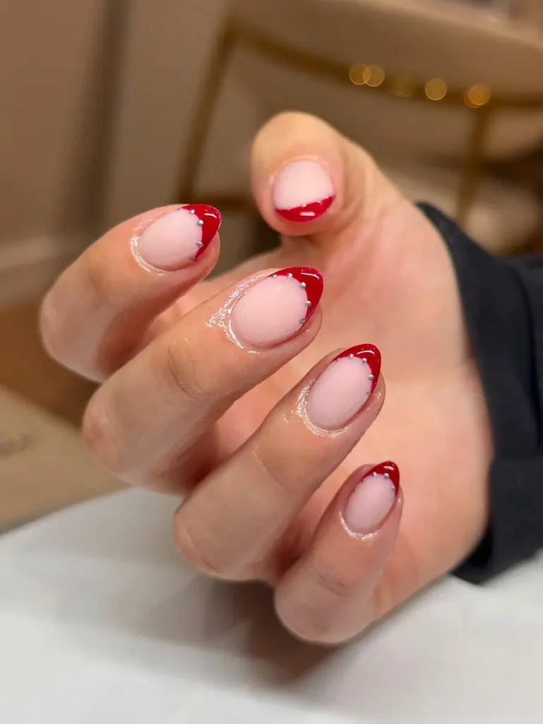 Short Red French Nails With Clean Tips and Tiny Stud Details