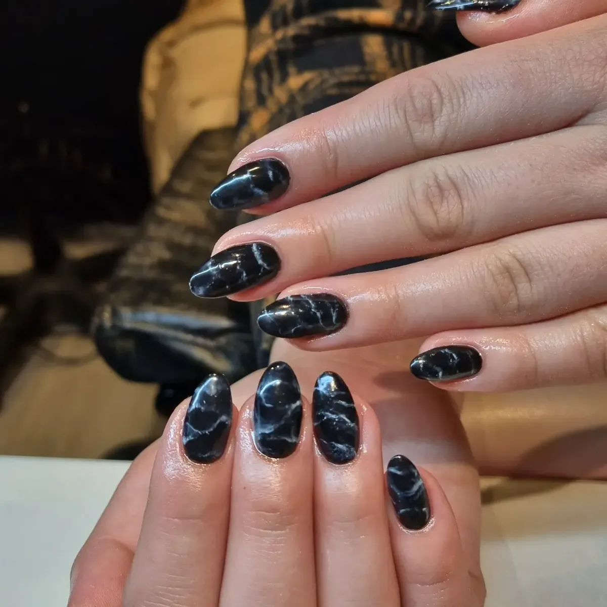 Glossy black marble effect almond nails