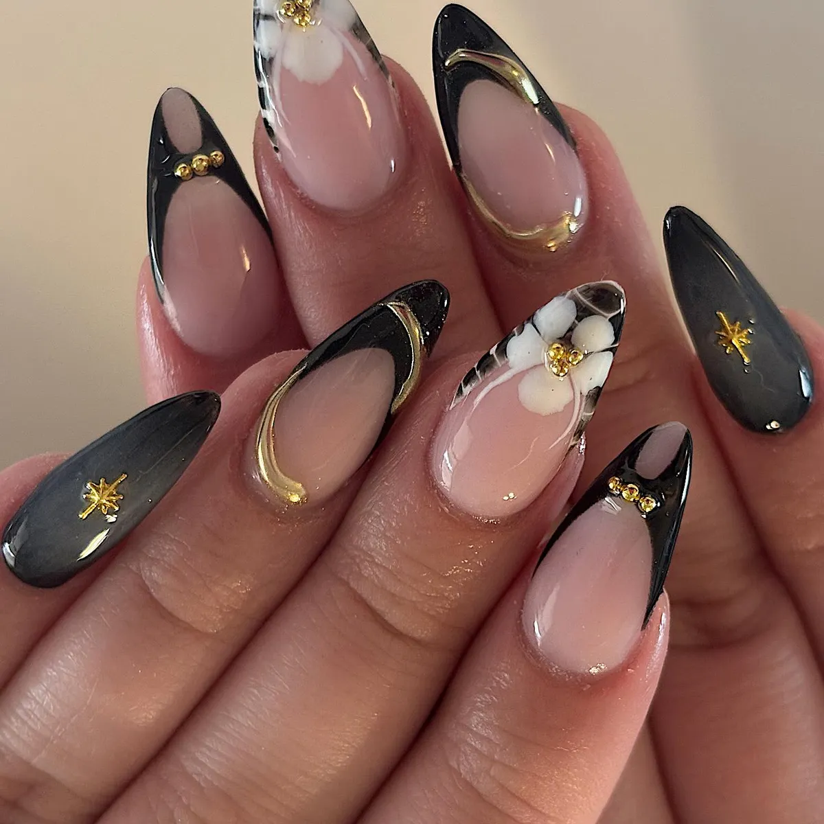 Black French tips with gold accents and white floral details