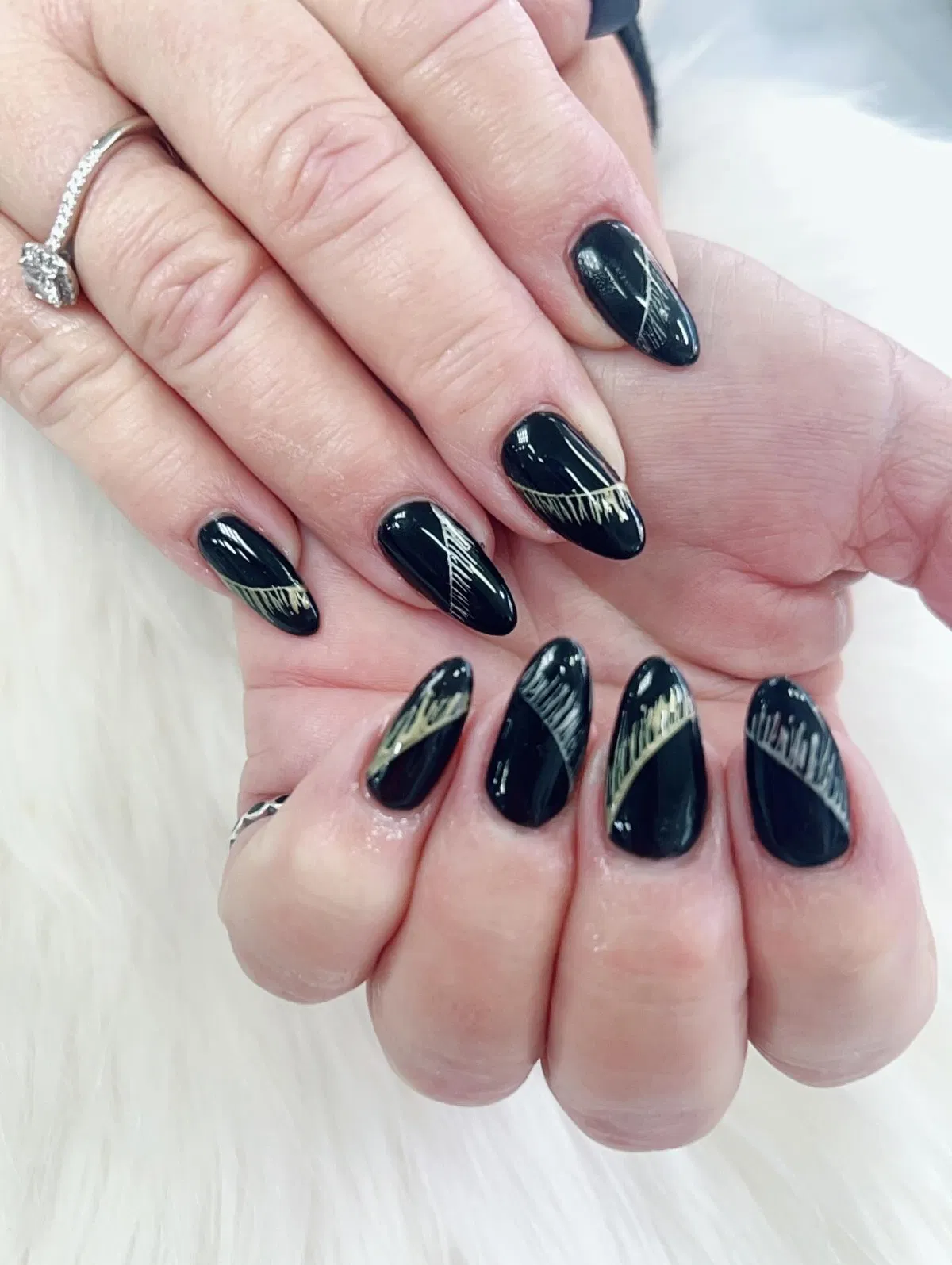 Glossy black nails with diagonal metallic gold striping