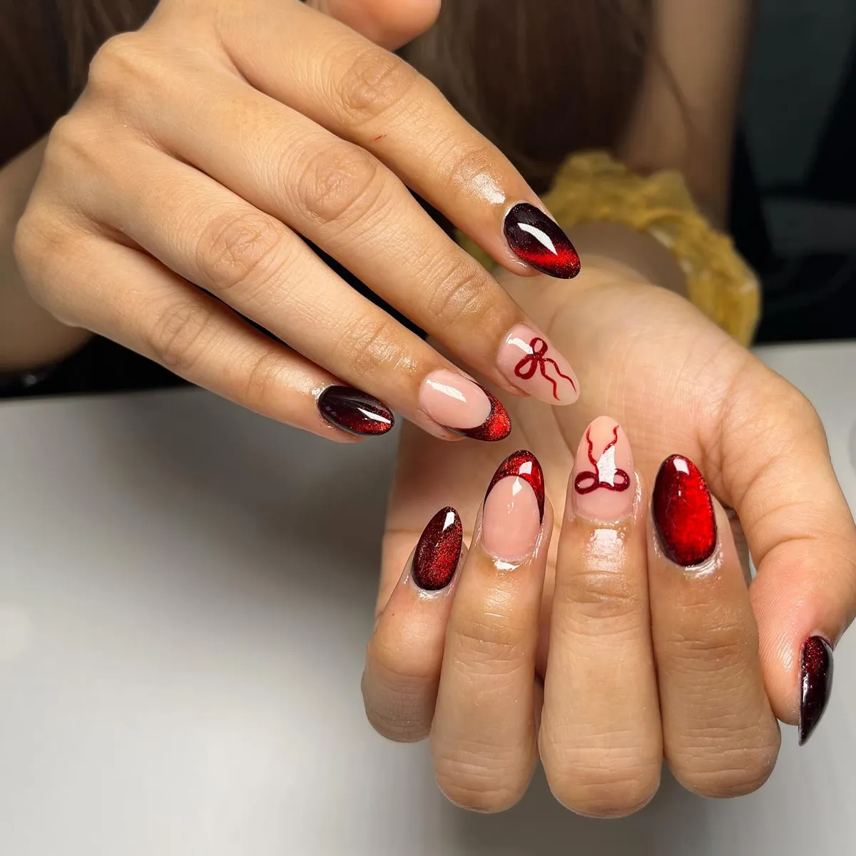 Red shimmer tips with ribbon-like line art