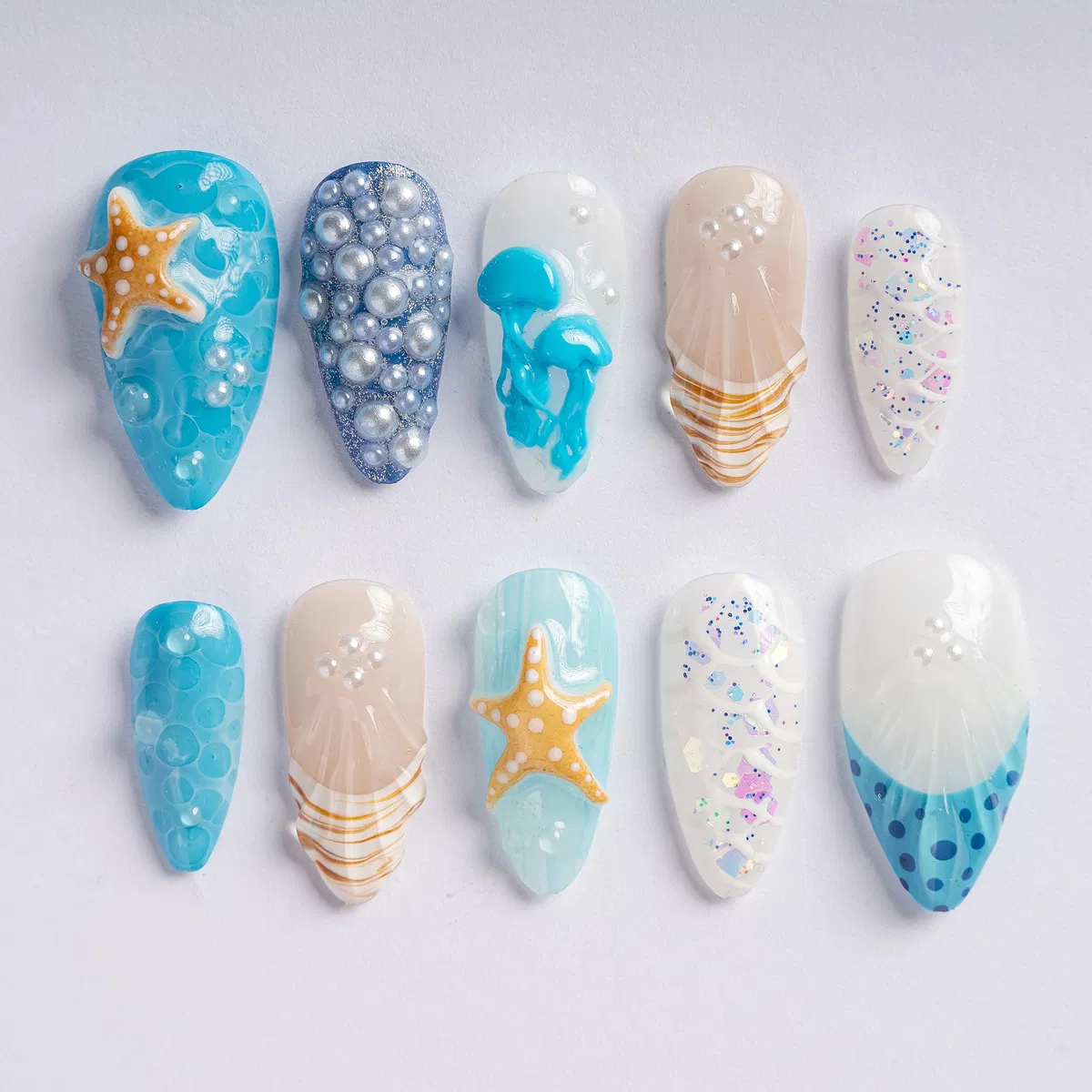 3D sea-inspired nail tips with pearls and confetti