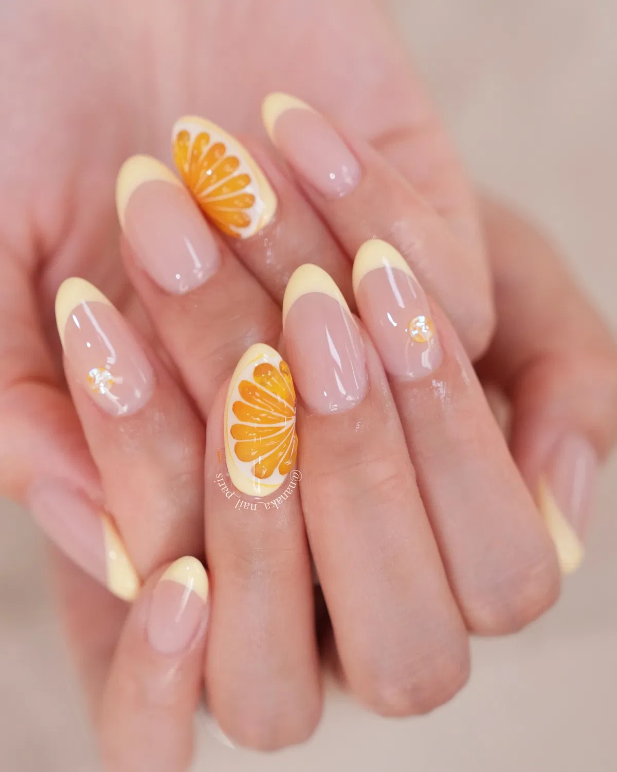 Pale yellow French tips with orange-slice accent nails