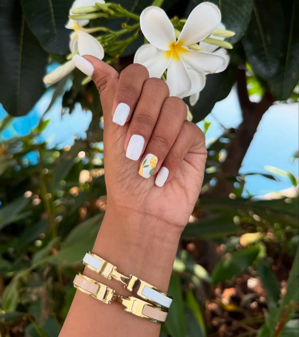 Solid white nails with a single yellow fruit accent