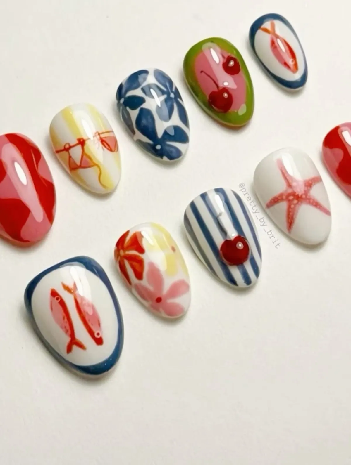 Mixed illustrated nail tips with fish, cherries, and stripes
