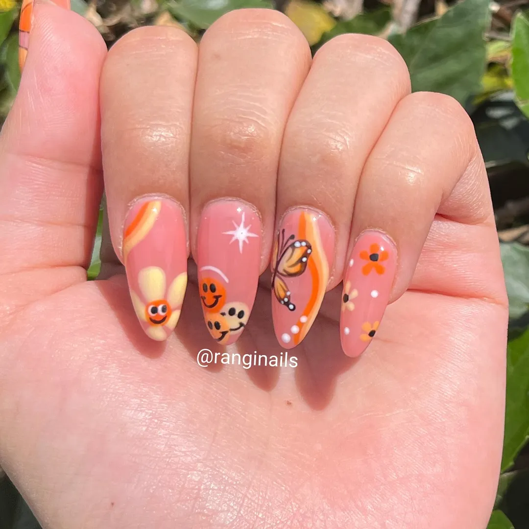 Coral nails with smileys, butterfly, and flower accents