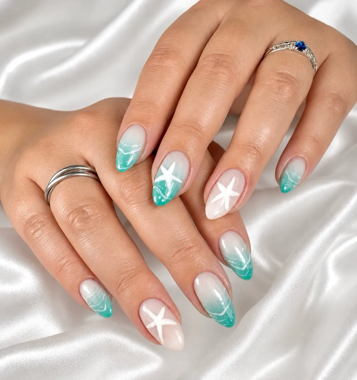 Teal ombré tips with white wave lines and starfish accents