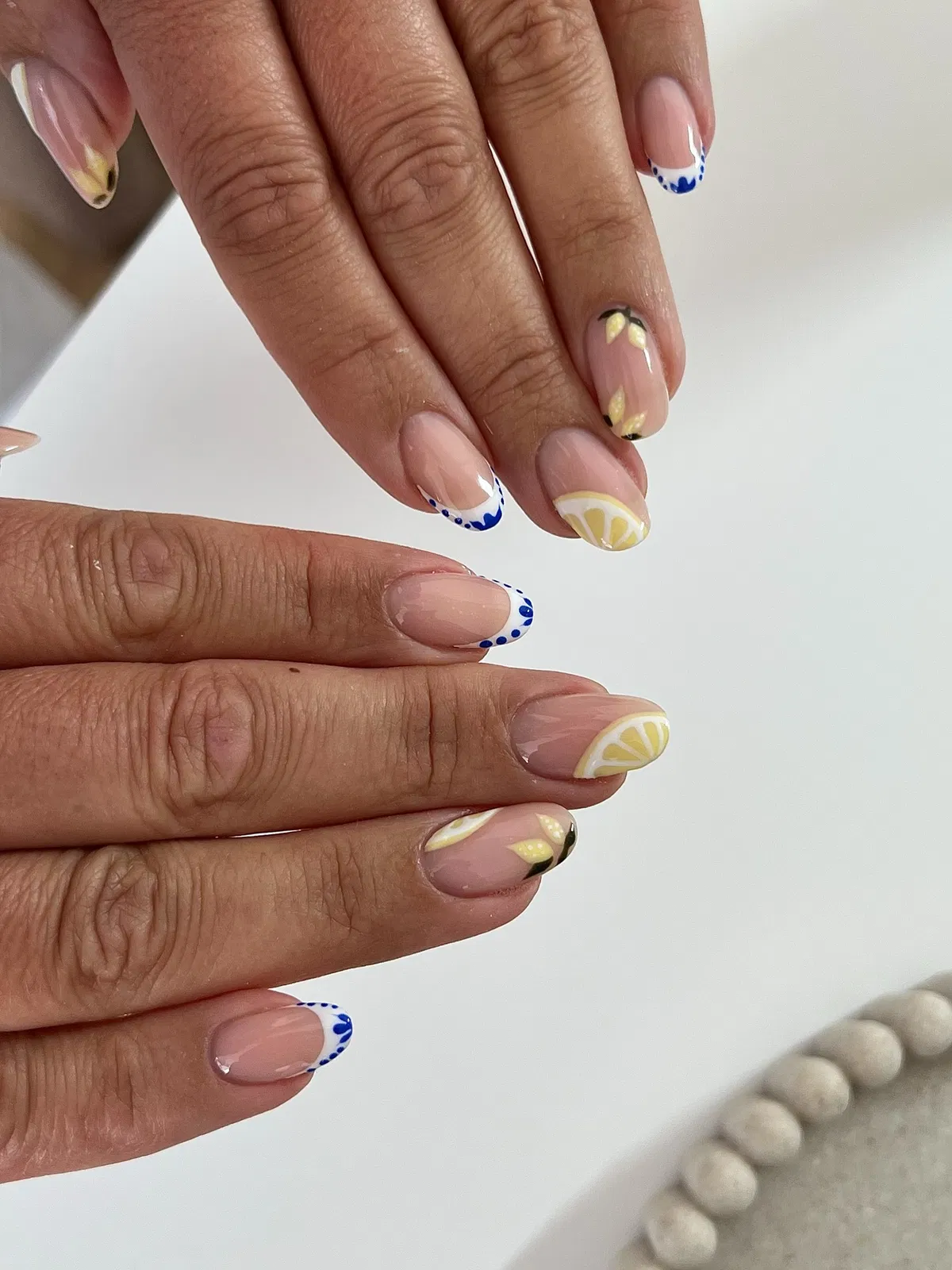Close-up of blue-detailed French tips with citrus accents