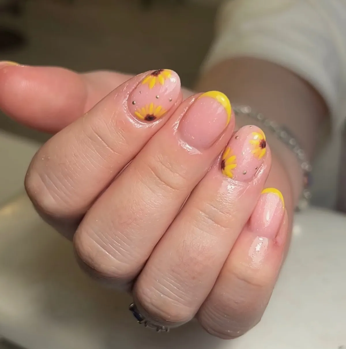 Nude short nails with yellow tips and tiny sunflowers