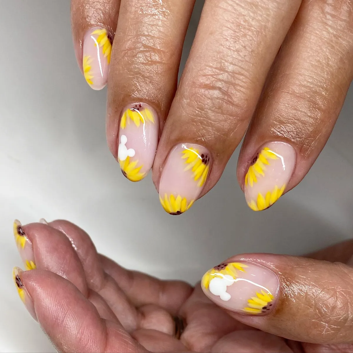 Nude base with sunflower-edge petals and white abstract accents