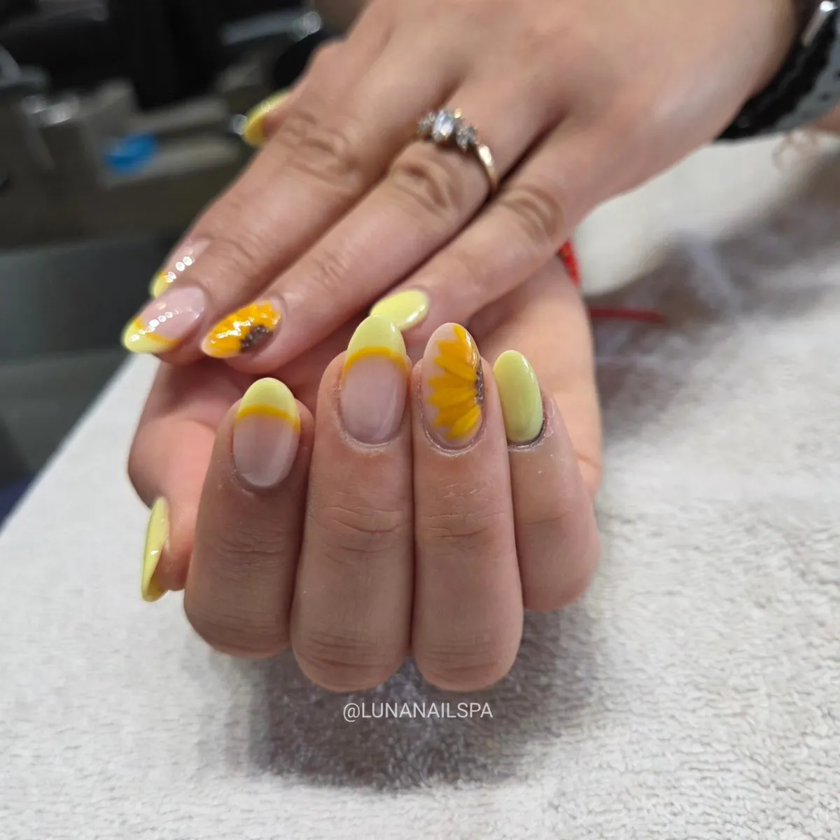 Thin yellow French tips with a large sunflower accent