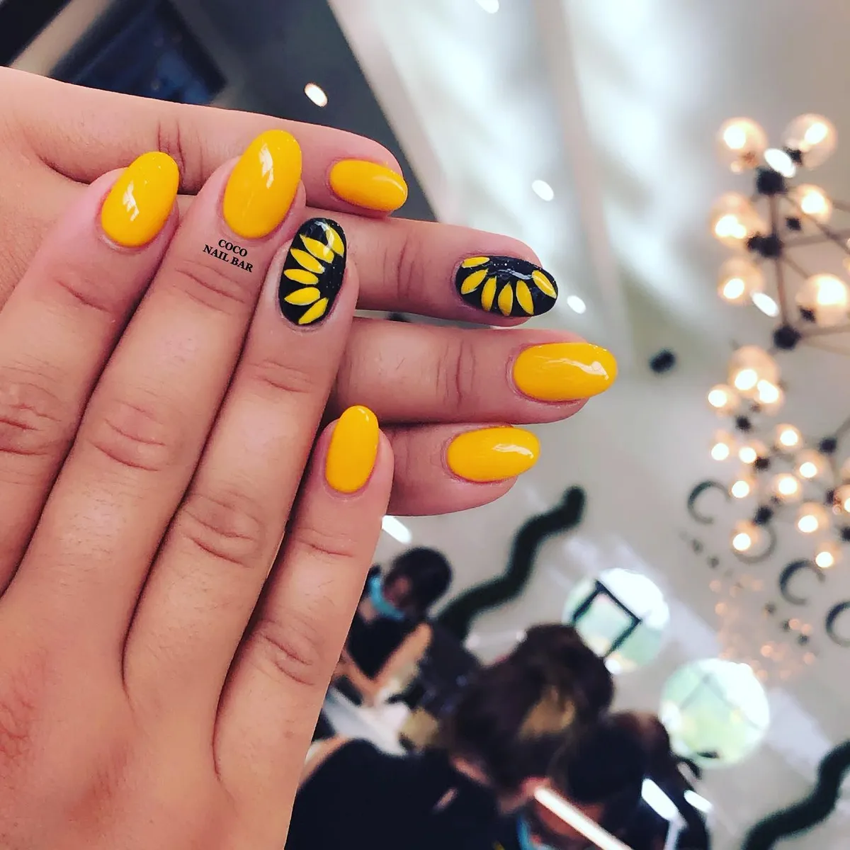 Yellow nails with black-and-yellow petal accents