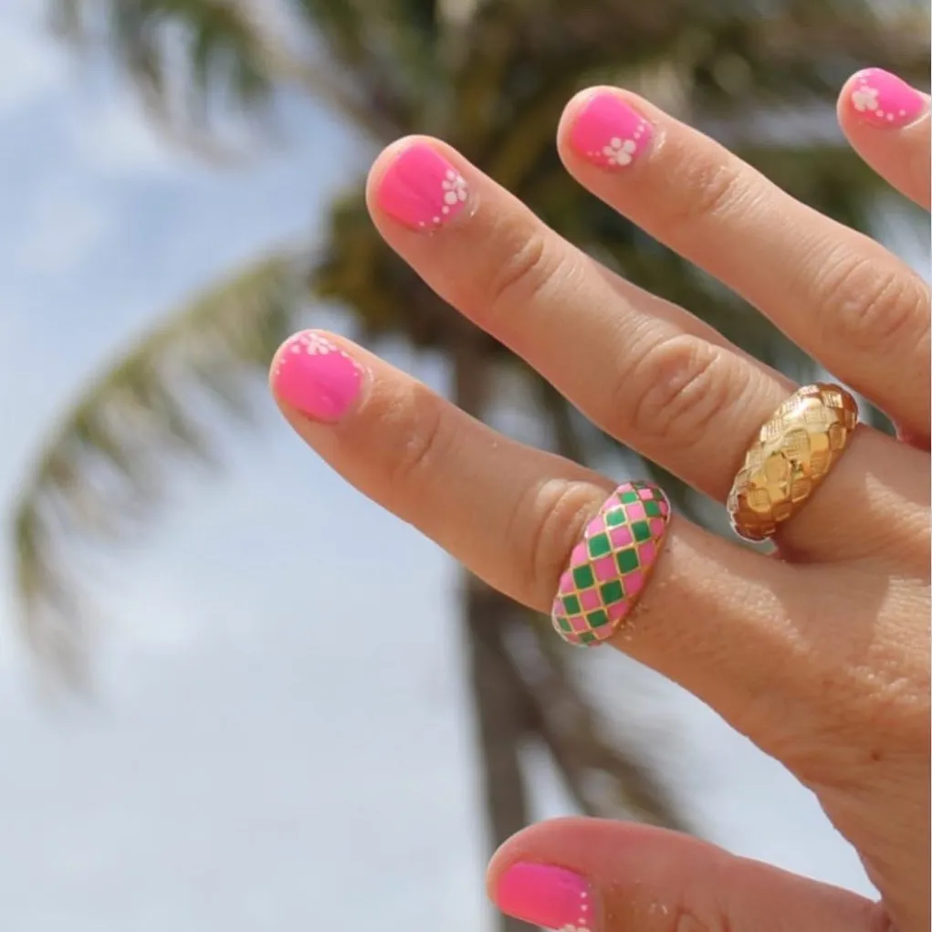 Bright pink short nails with tiny white floral clusters