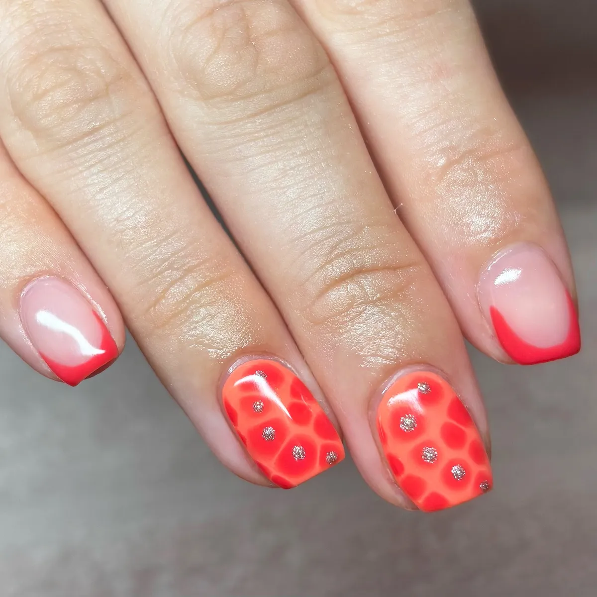 Red tips with spotted orange-red accent nails