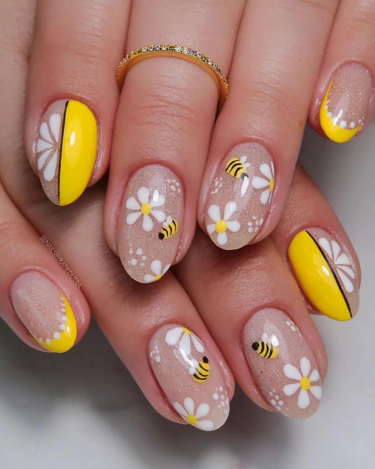 Glittery nude base with daisies, bees, and bold yellow curves