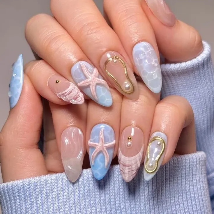 Soft blue ripple nails with 3D starfish and pearl-framed accents