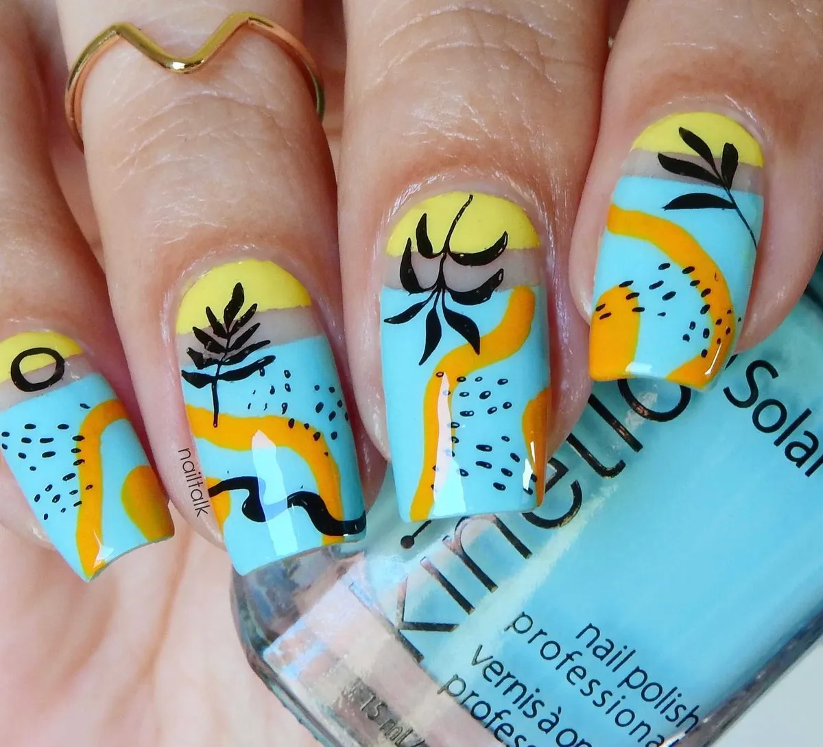 Graphic blue-and-yellow nails with black silhouettes