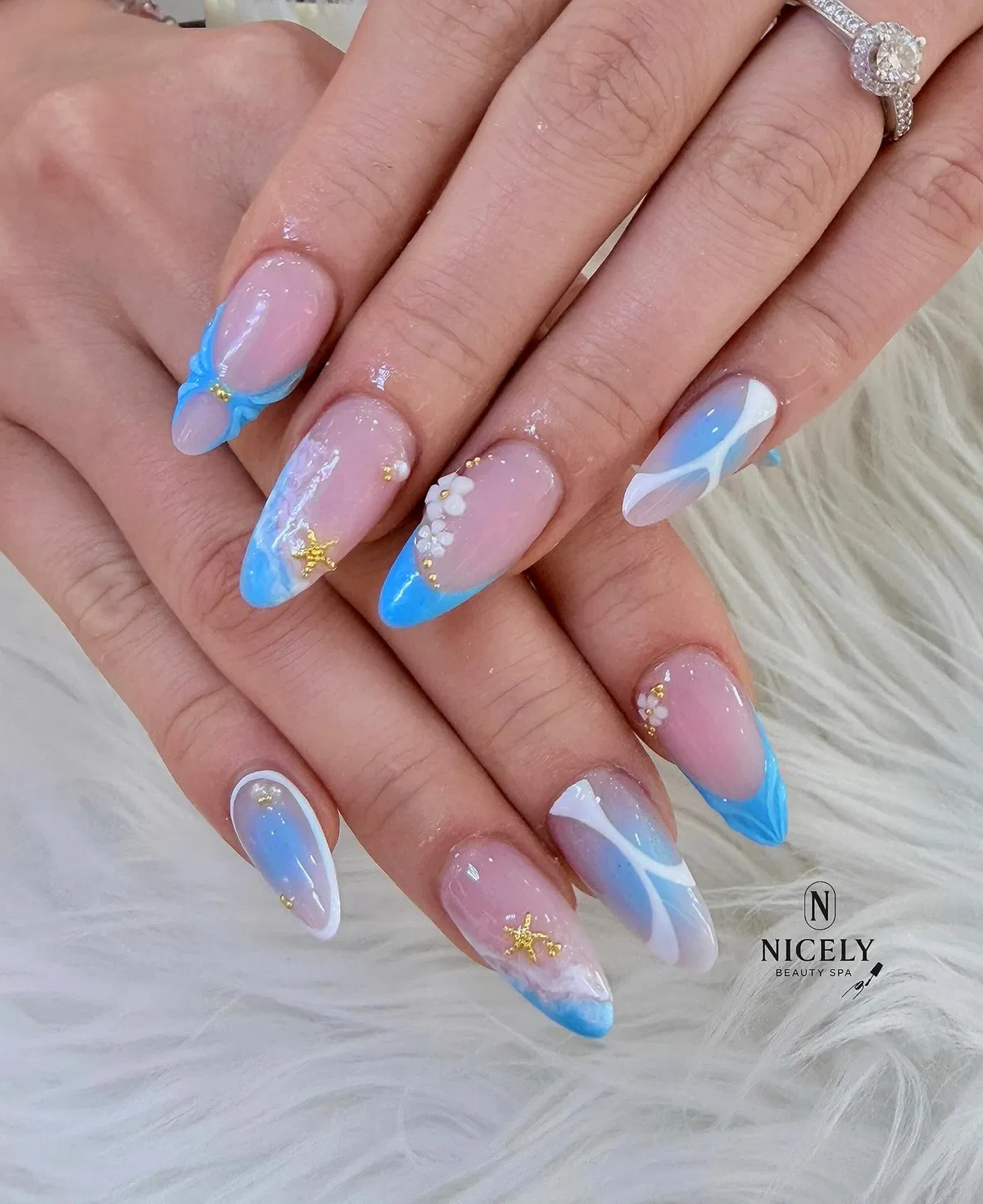Blue French tips with wave lines and gold starfish accents