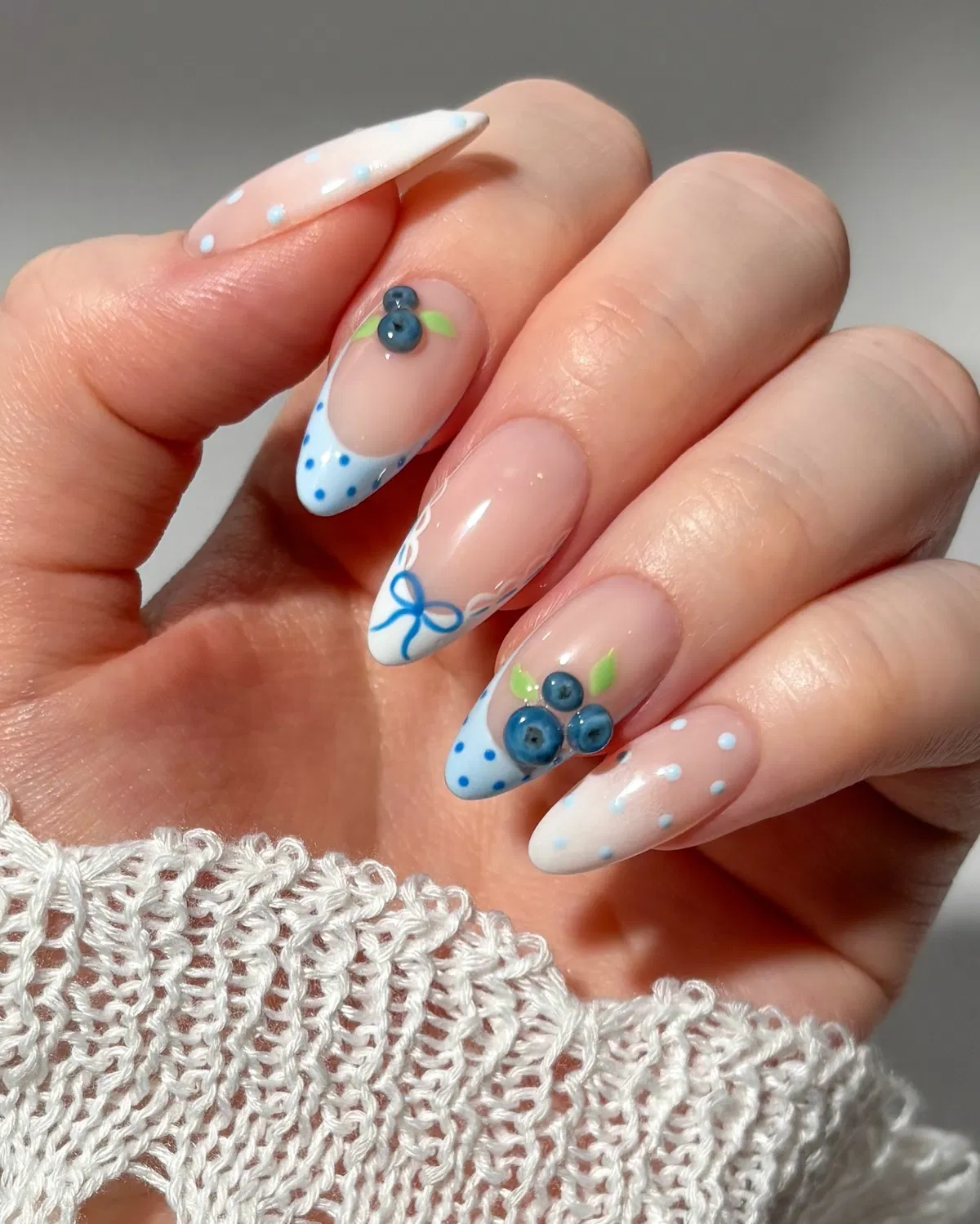 Blue polka-dot French tips with 3D berry accents
