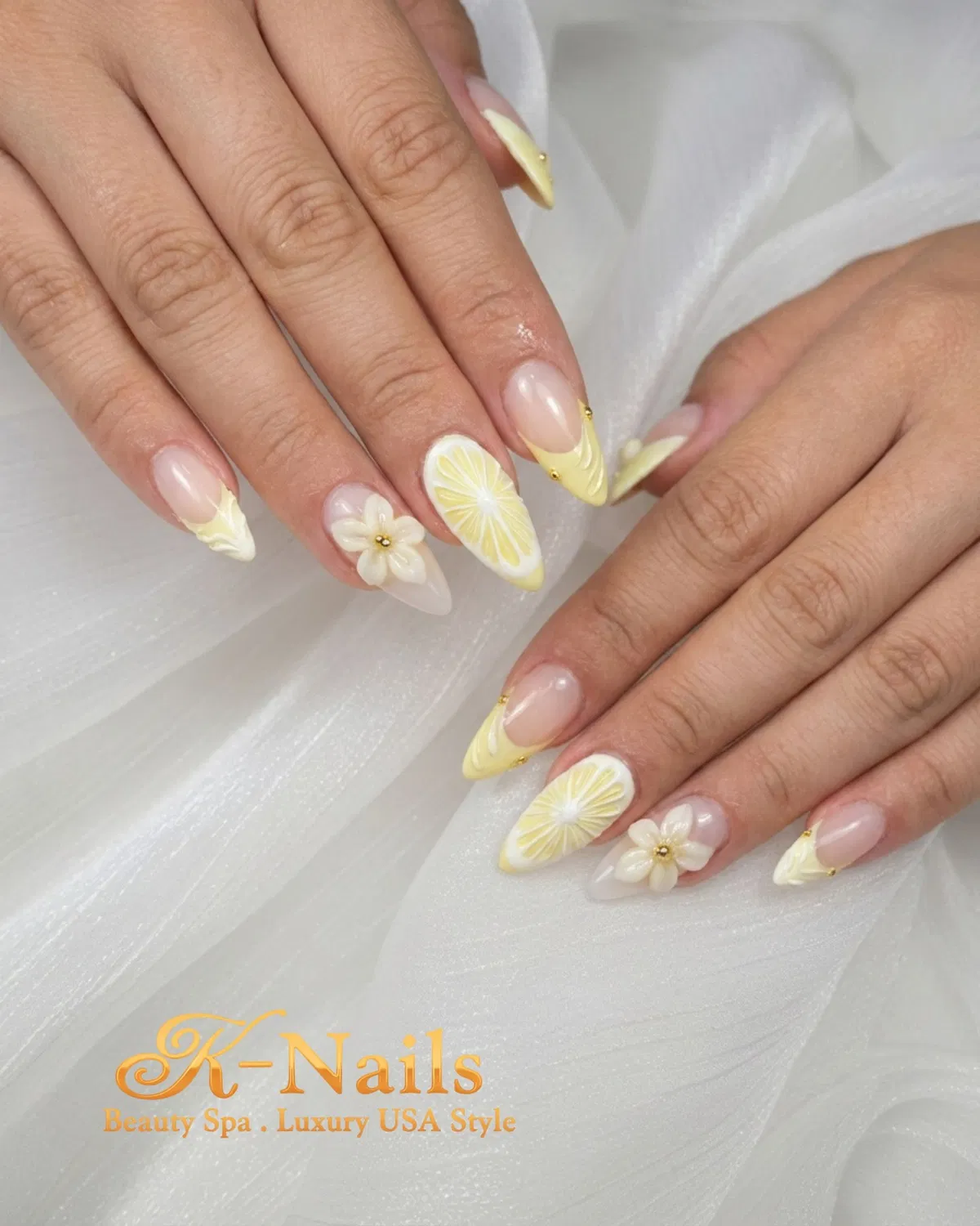 Pale yellow French tips with citrus slices and 3D white flowers
