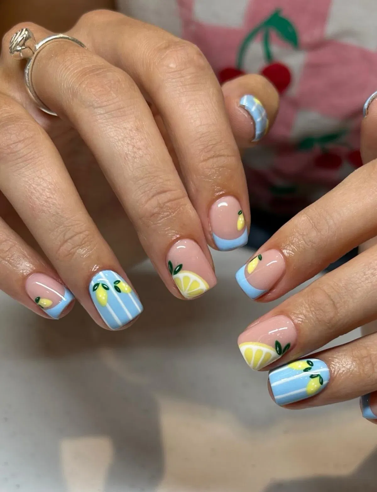 Light-blue tips and striped lemons on a nude base