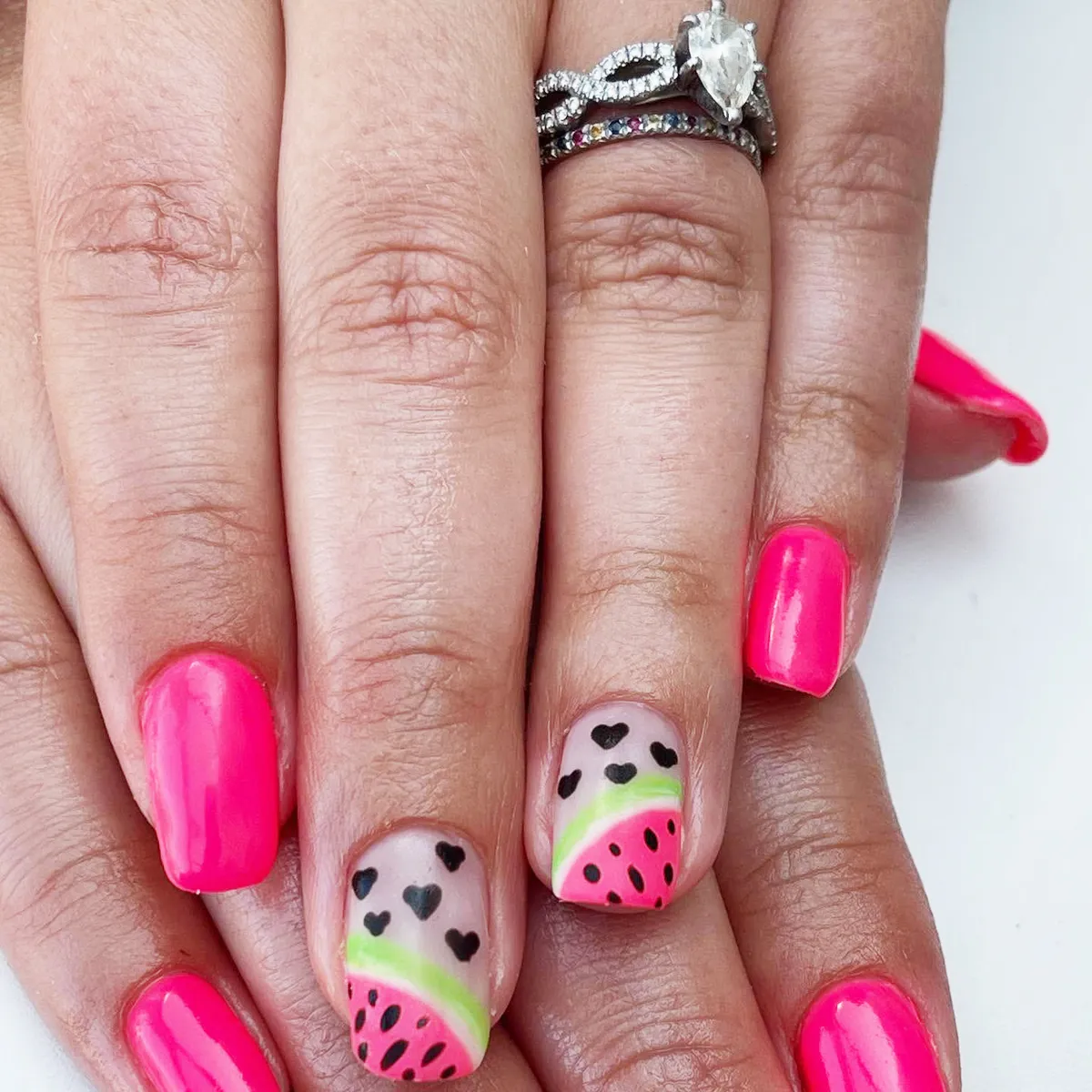 Hot pink nails with heart-and-seed accent design