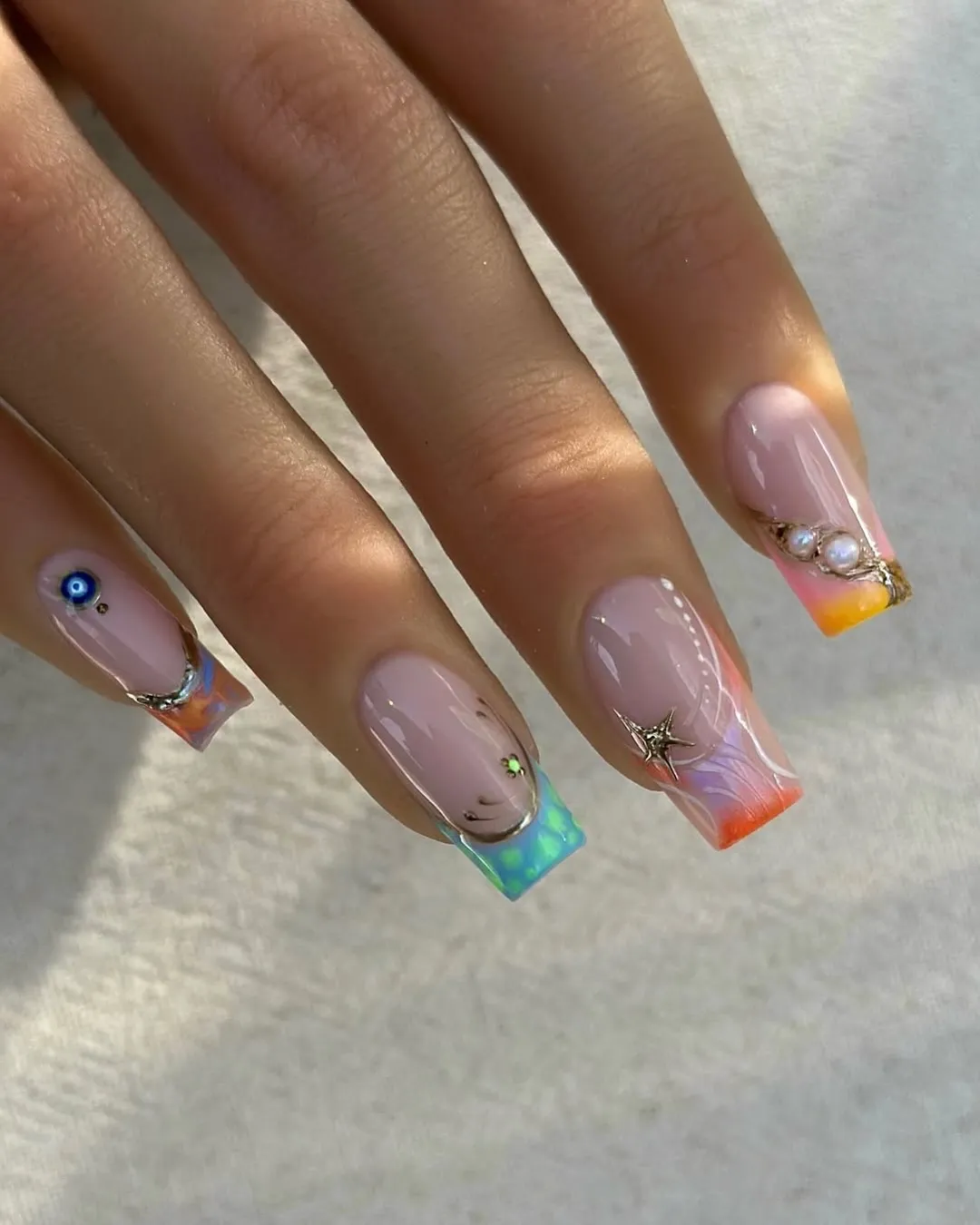 Mixed-color square tips with eye symbol and pearl cluster