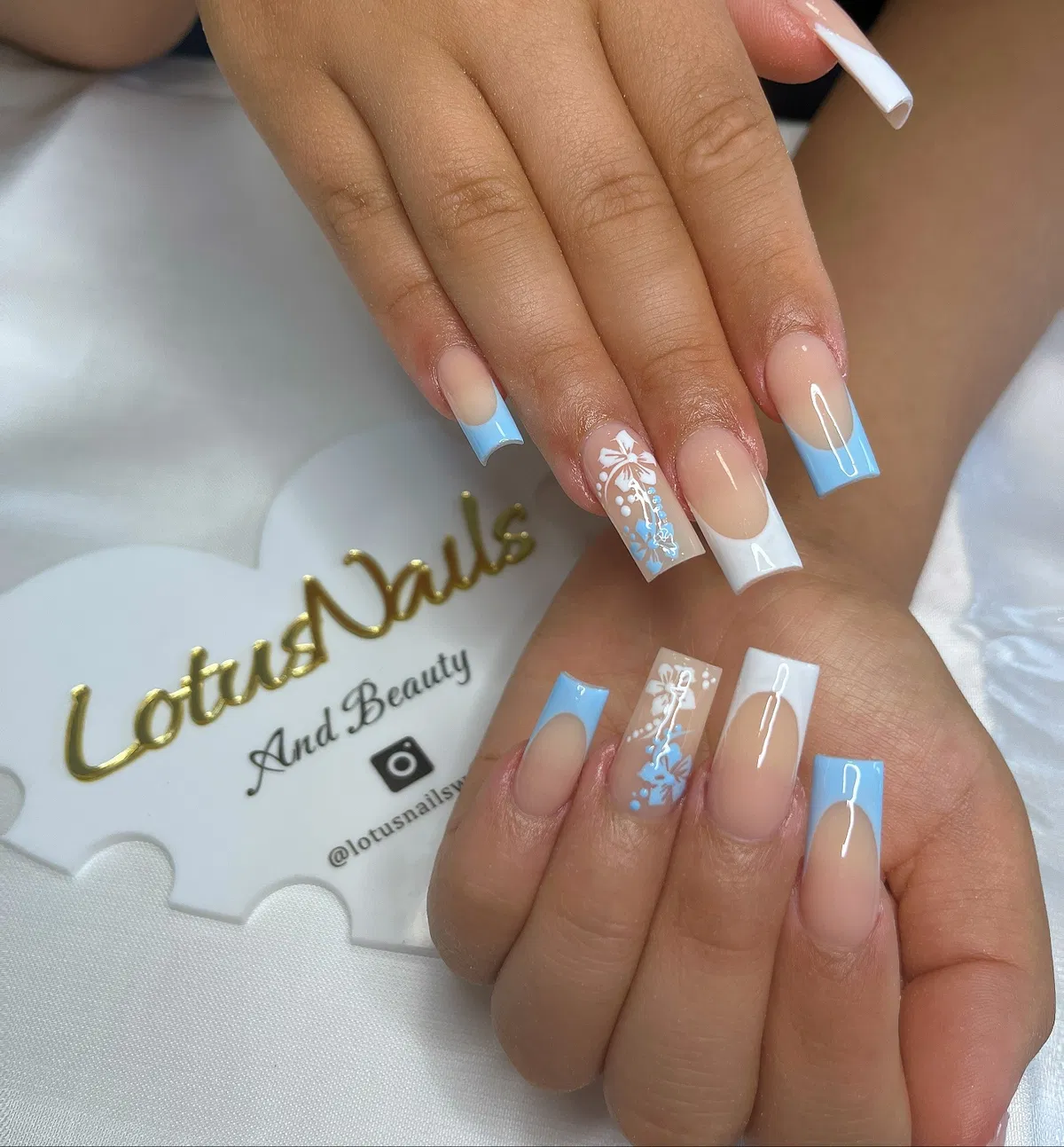 Light blue and white French tips with white floral accent