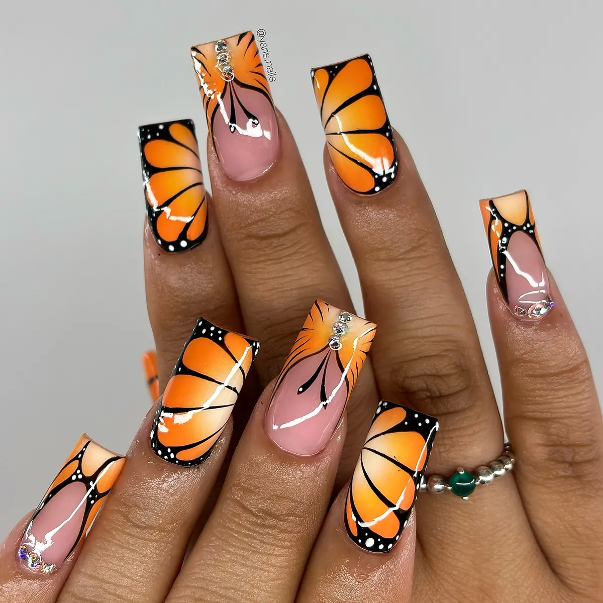 Orange-and-black wing pattern square nails with rhinestones