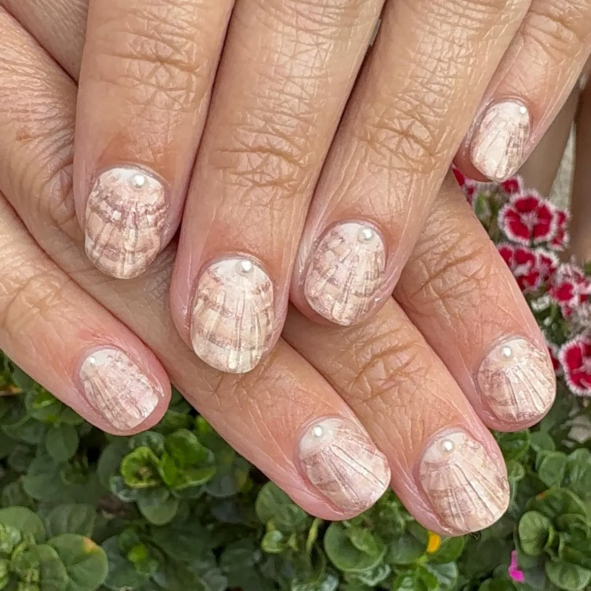 Pearly nude nails with shell-like linework and tiny pearls