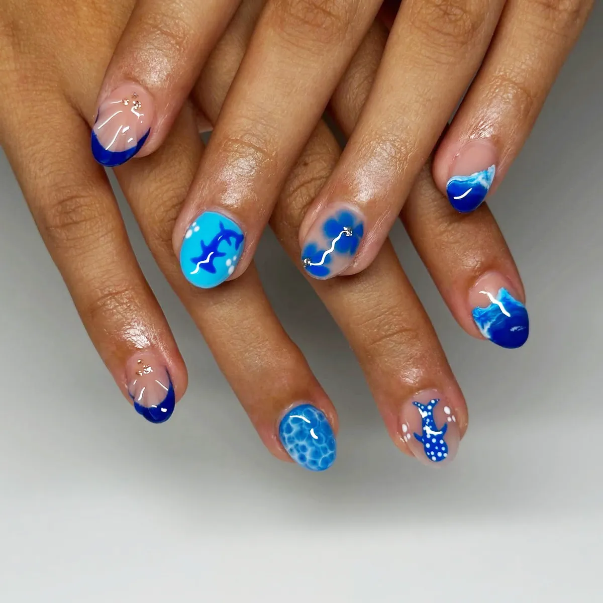 Blue wave tips with dolphin and mermaid-tail motifs