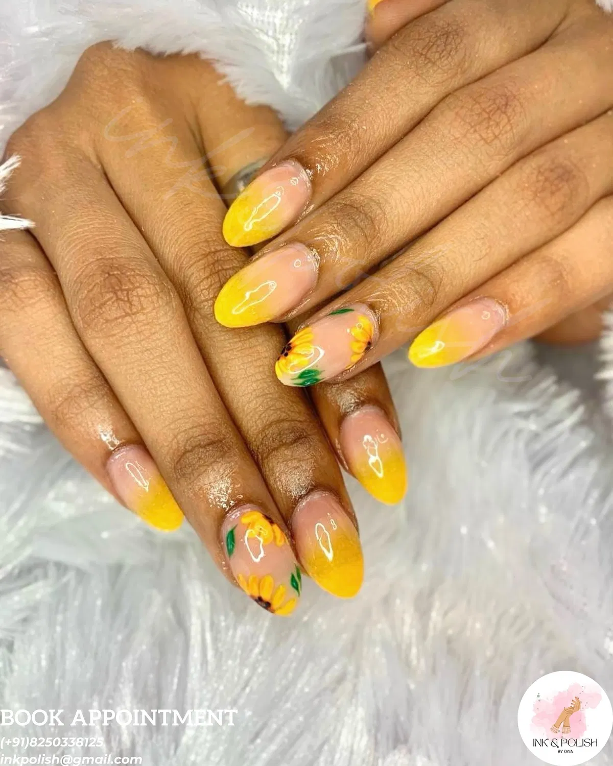 Yellow ombrΓ© almond nails with sunflower accents and salon text overlay