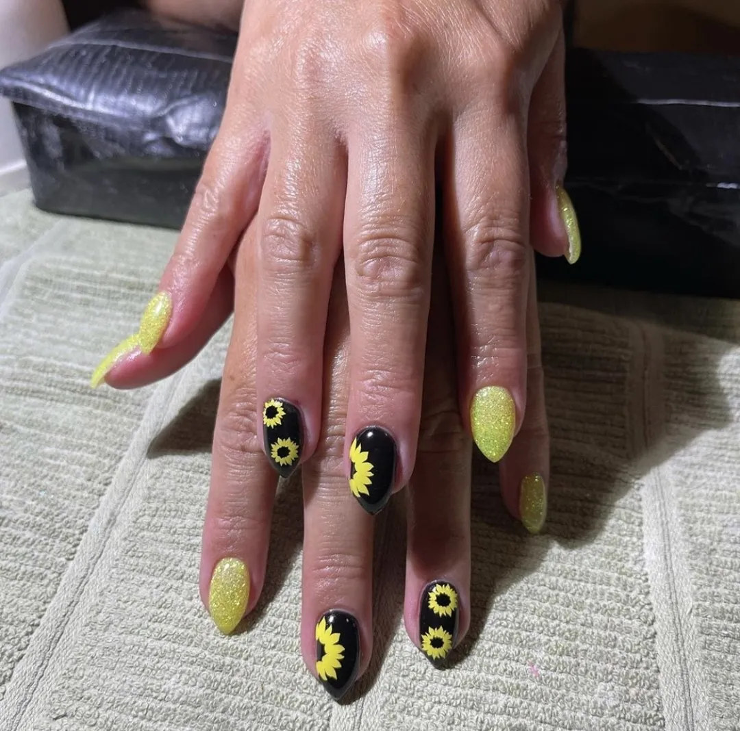 Yellow glitter nails paired with black sunflower art