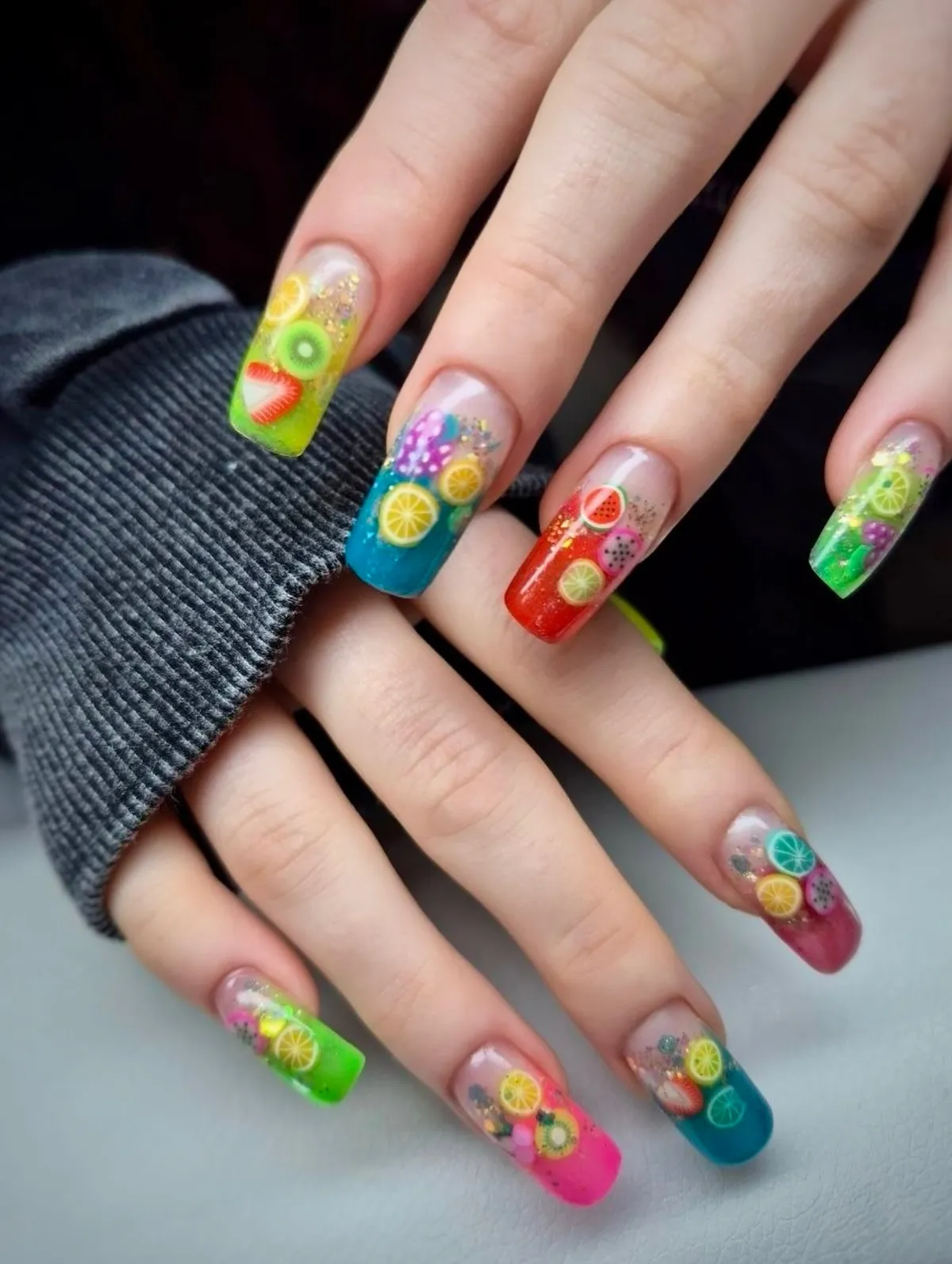 Clear fruit-slice nails with bright colored tips and glitter