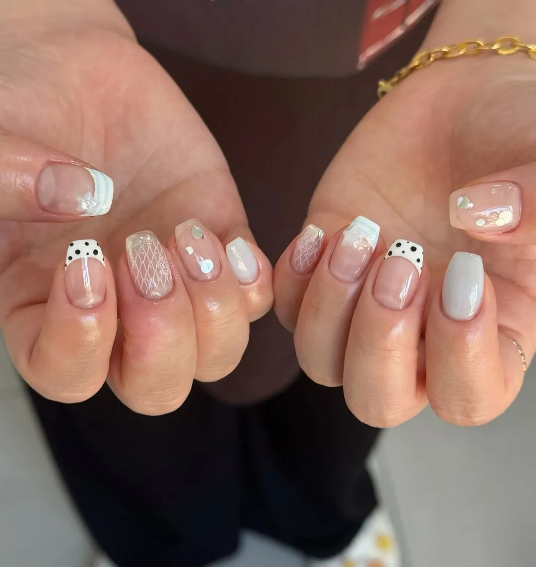 Short nude nails with dotted French tips and lace accents
