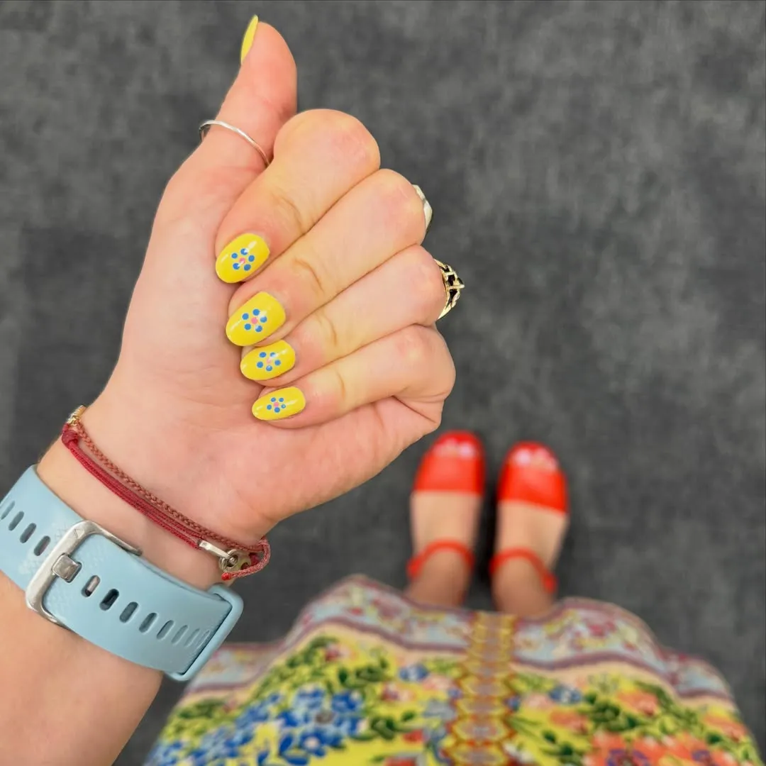 Bright yellow nails with colorful dot clusters