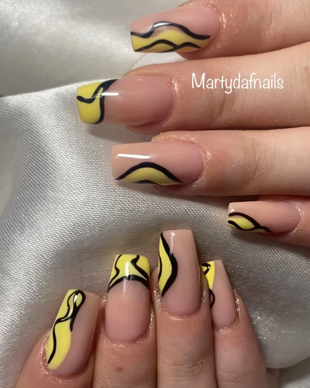 Abstract yellow-and-black wavy line nails