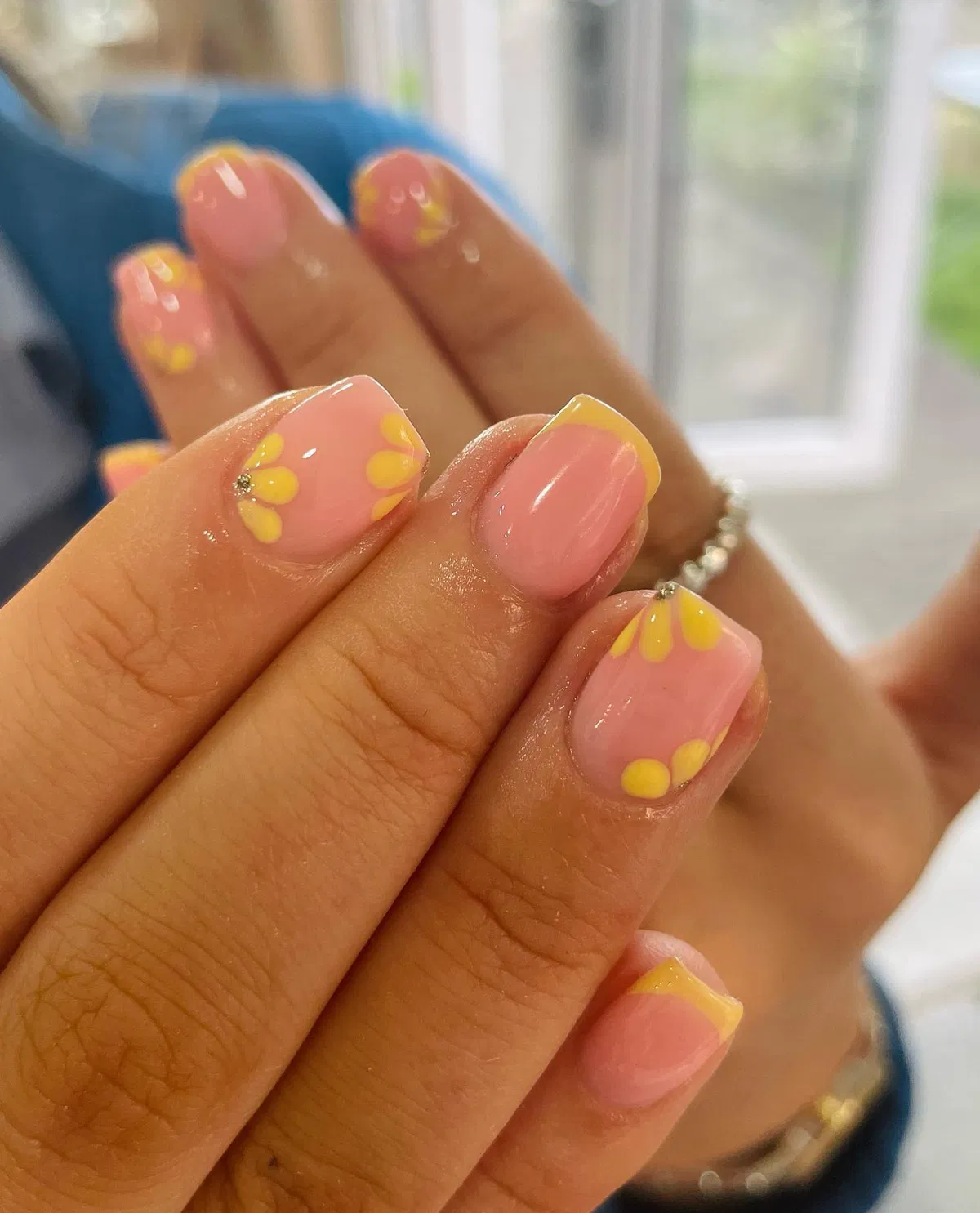 Soft pink nails with pale yellow tips and petals