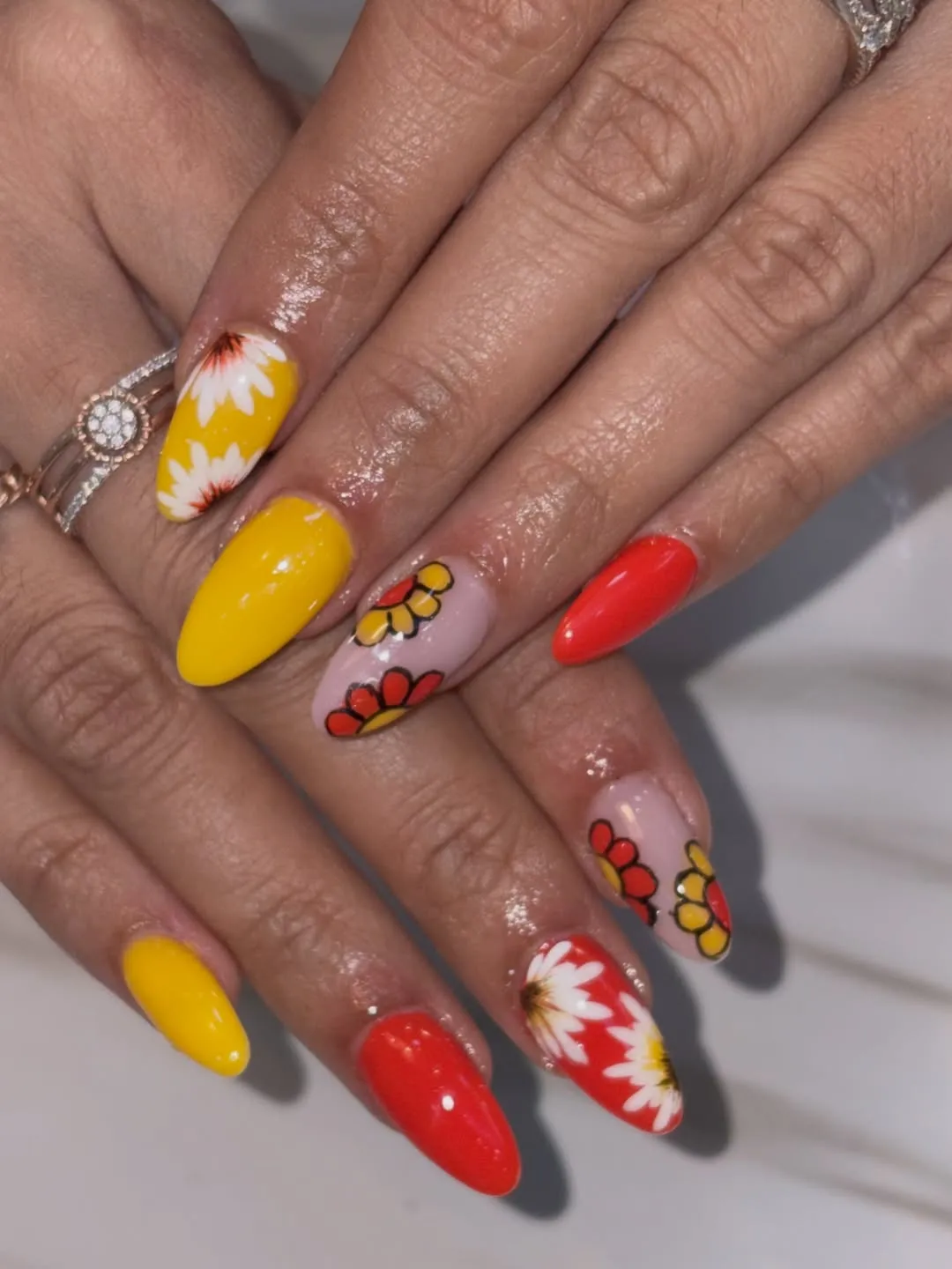 Yellow and red nails with bold floral designs