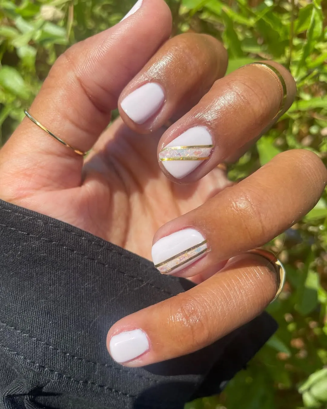 Glossy white short nails with diagonal gold and iridescent striping