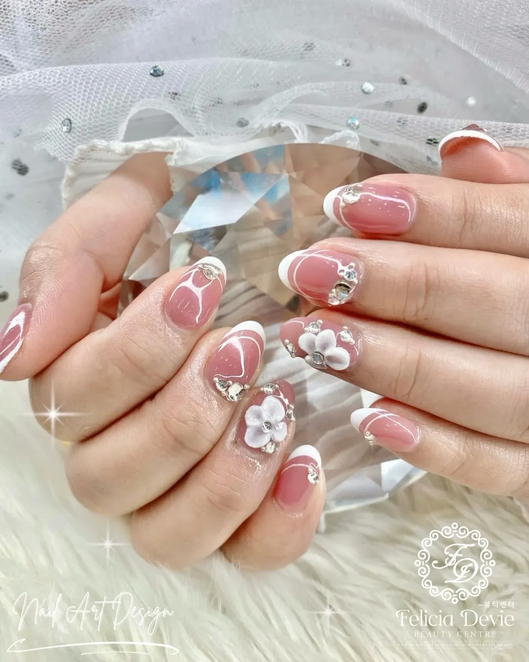 Pink French tips with curved white lines and rhinestones