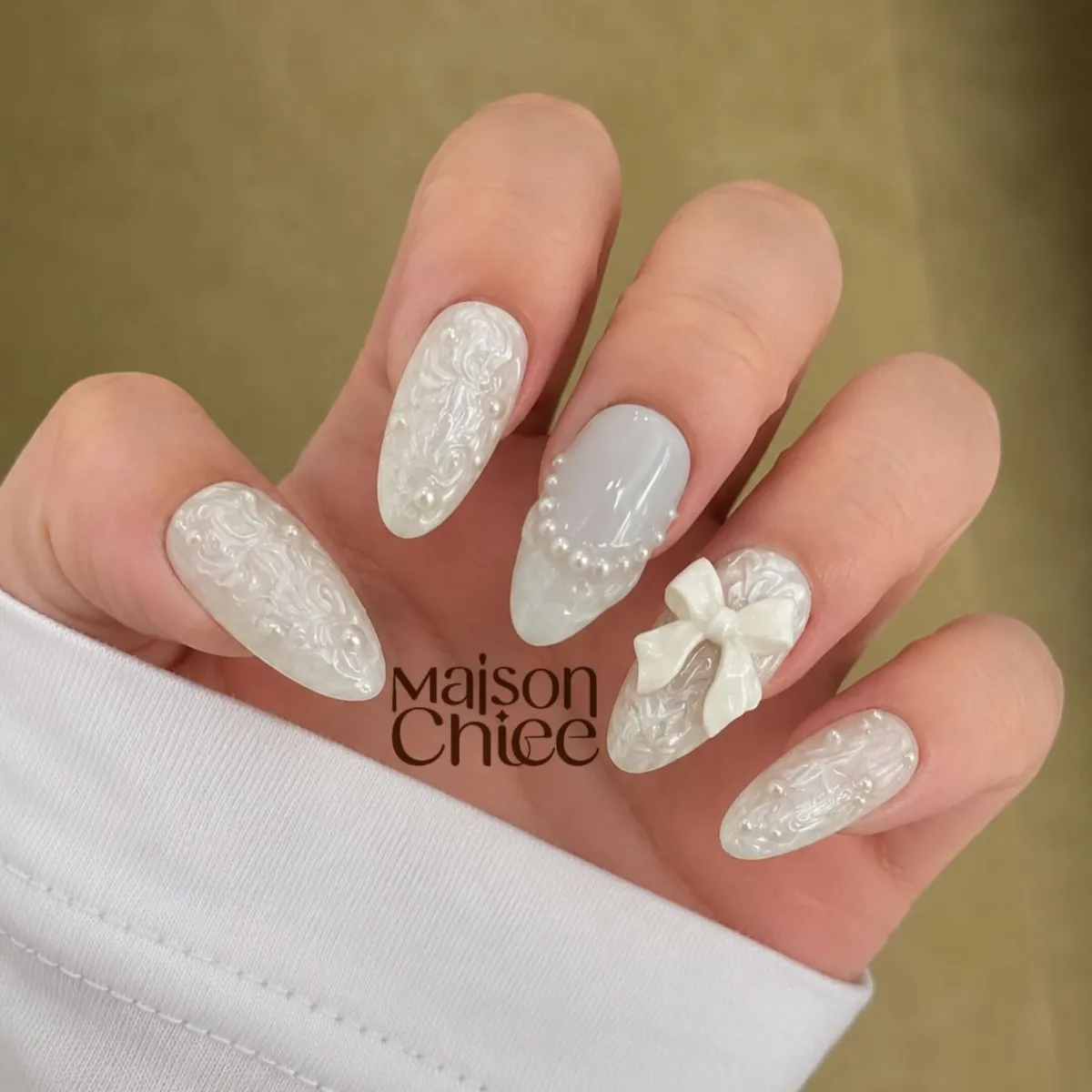 Milky white embossed nails with bow accent