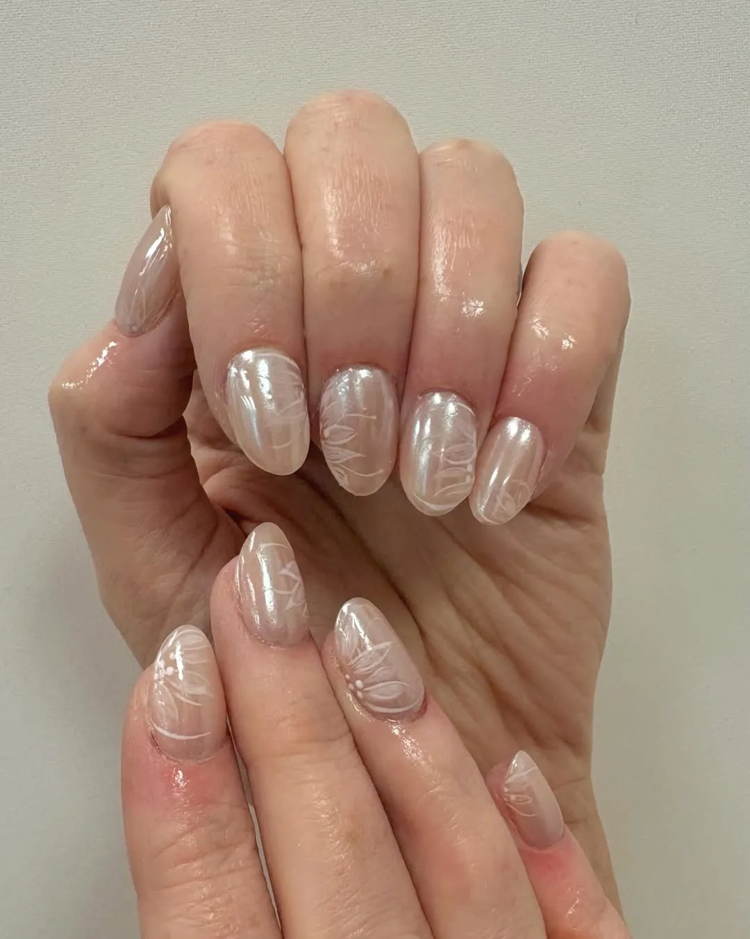 Iridescent nude nails with white line florals
