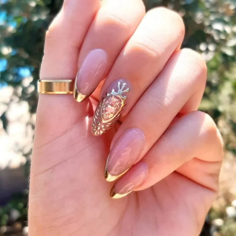 Gold French tips with ornate framed accent nail