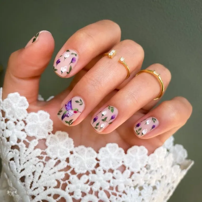 Short nude nails with purple-and-white floral painting