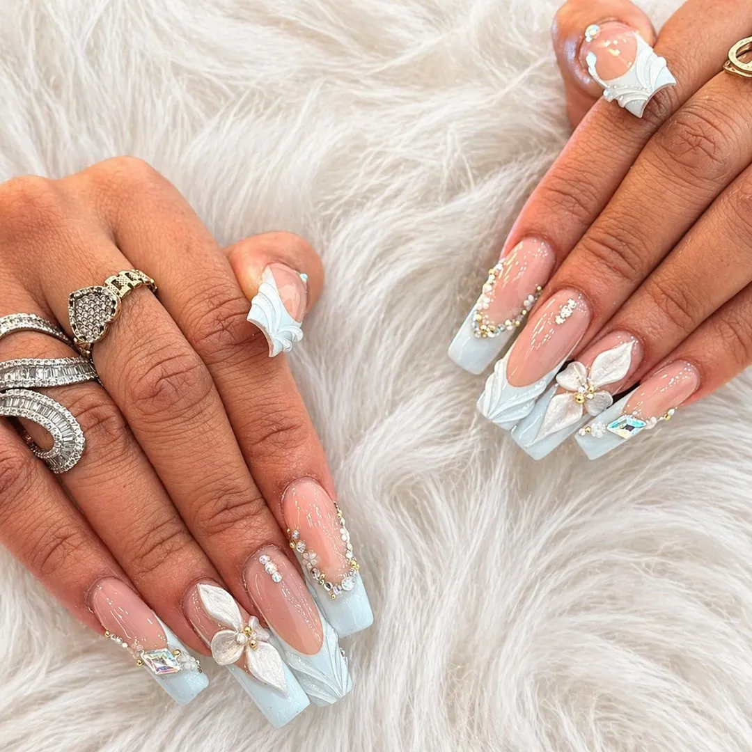 Pale blue French tips with 3D white florals and rhinestones