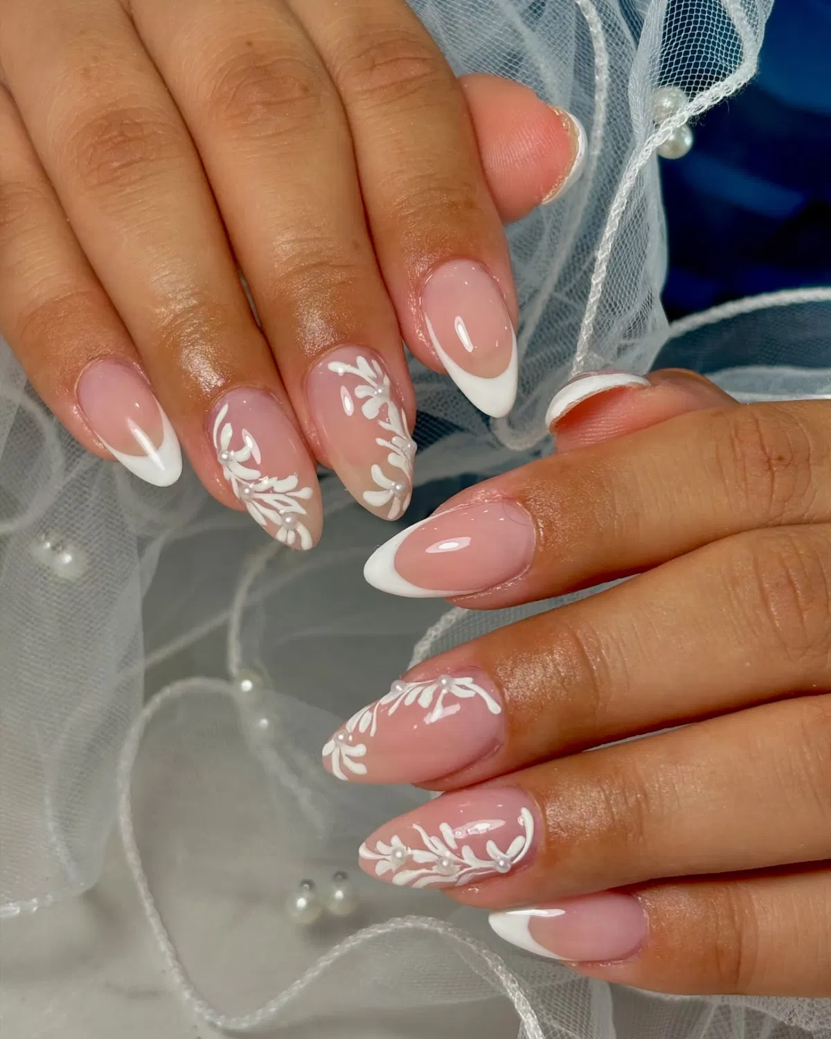 Almond French tips with white vine art and pearl-like beads