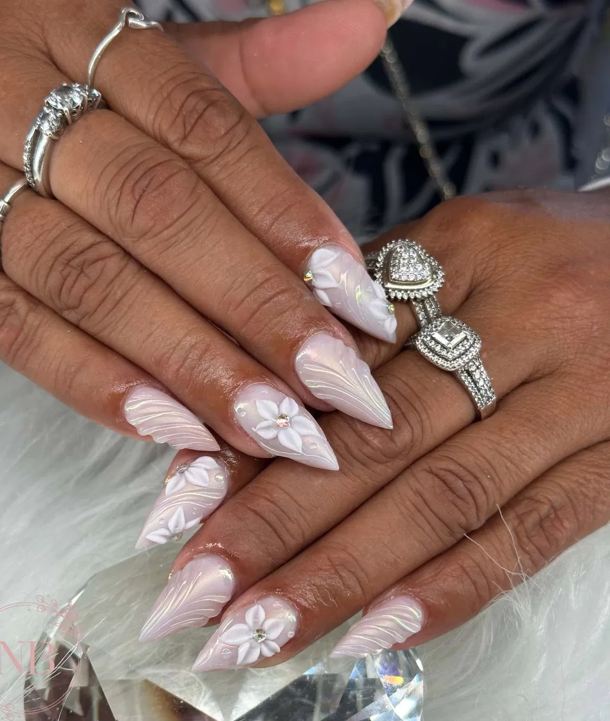 Pale pink pointed nails with 3D white flowers and swirl lines