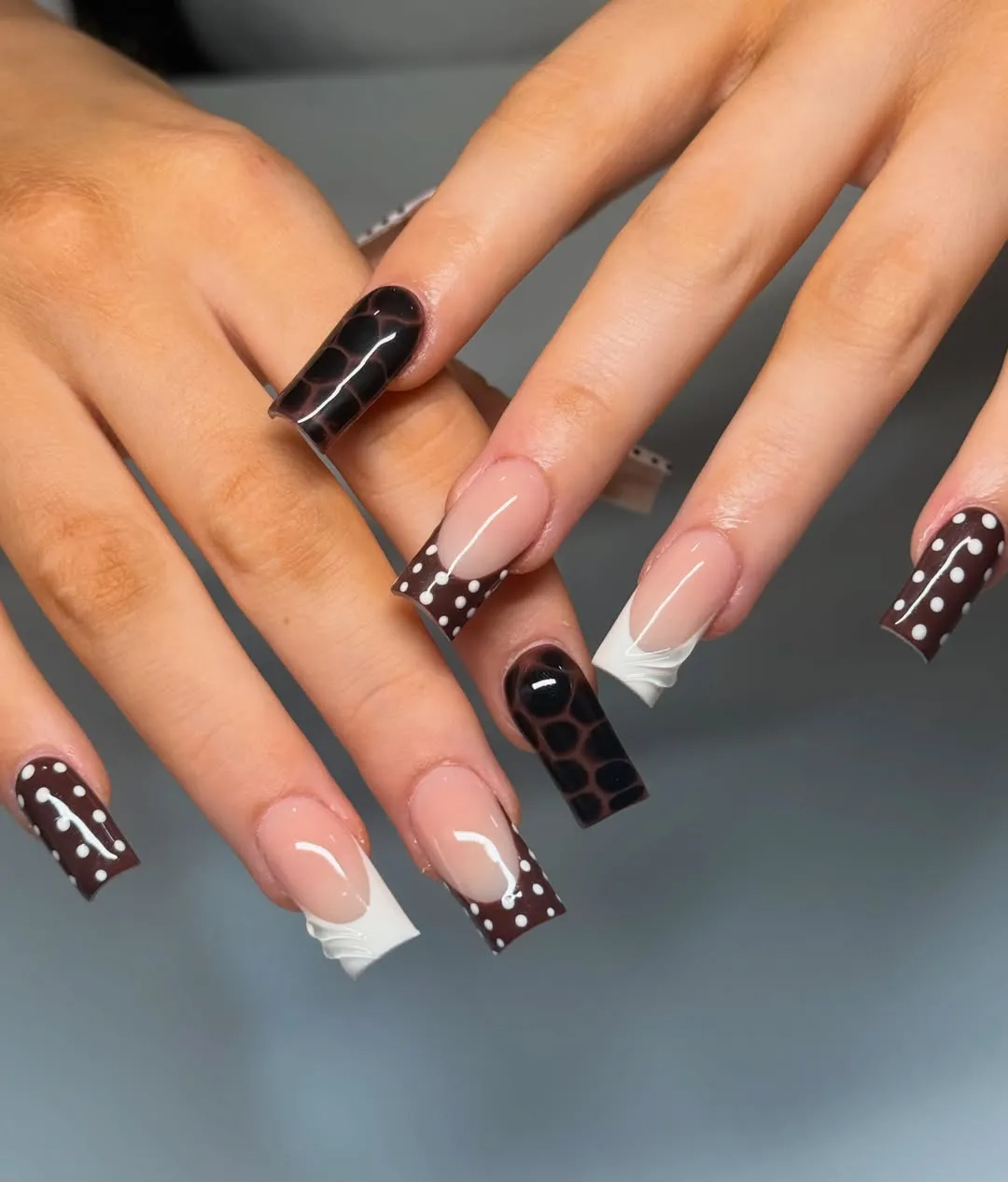 Dark brown polka-dot French tips with mixed white accents