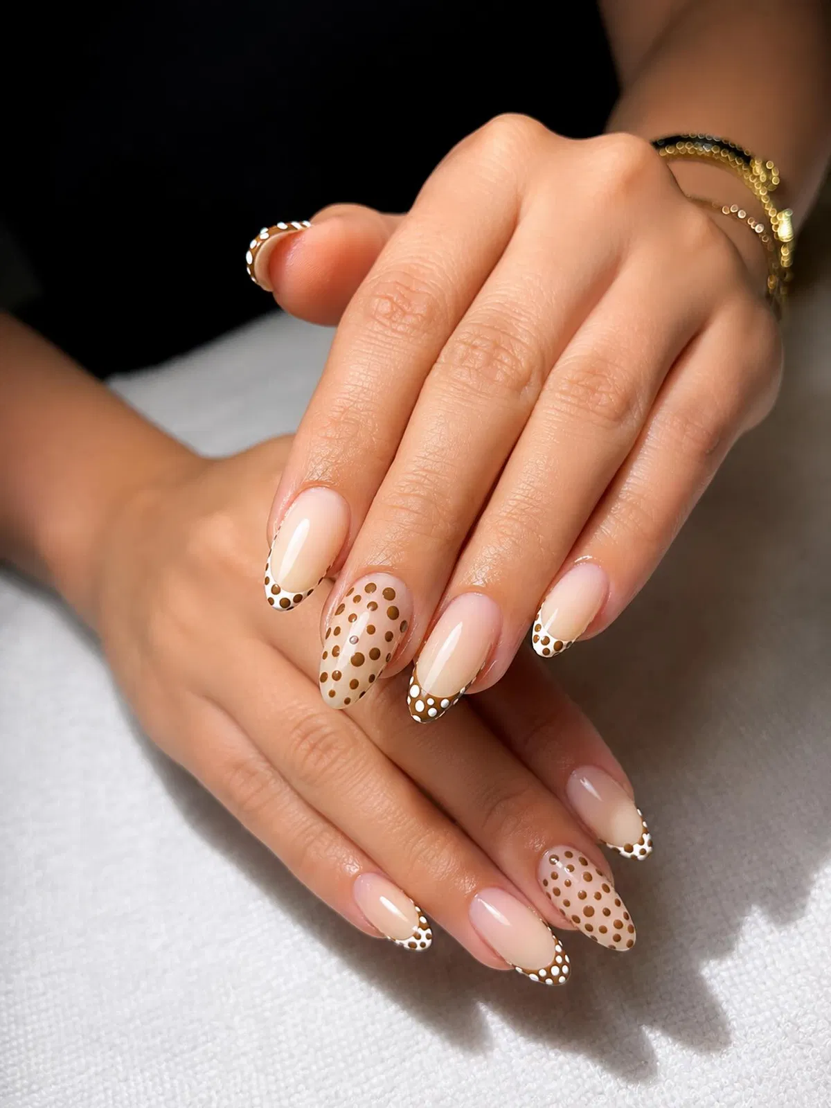 Classic brown polka-dot French tips with one full polka-dot accent